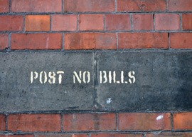 Brick wall with post no bills stencilled sign