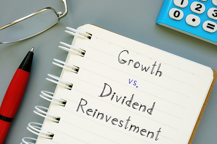 Business concept meaning Growth vs. Dividend Reinvestment with sign on the sheet.