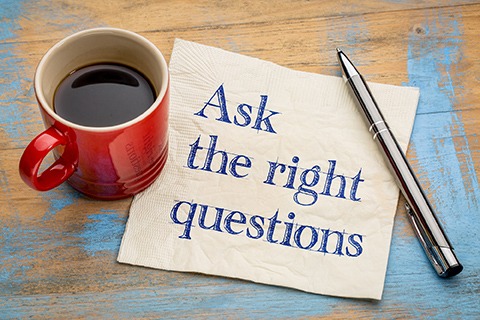 Ask the right questions - handwriting on a napkin with a cup of coffee - Miller on the Money